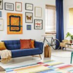 a living room with a blue couch and a table with a bicycle