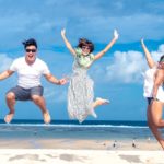 a group of people jumping in the air with their arms out