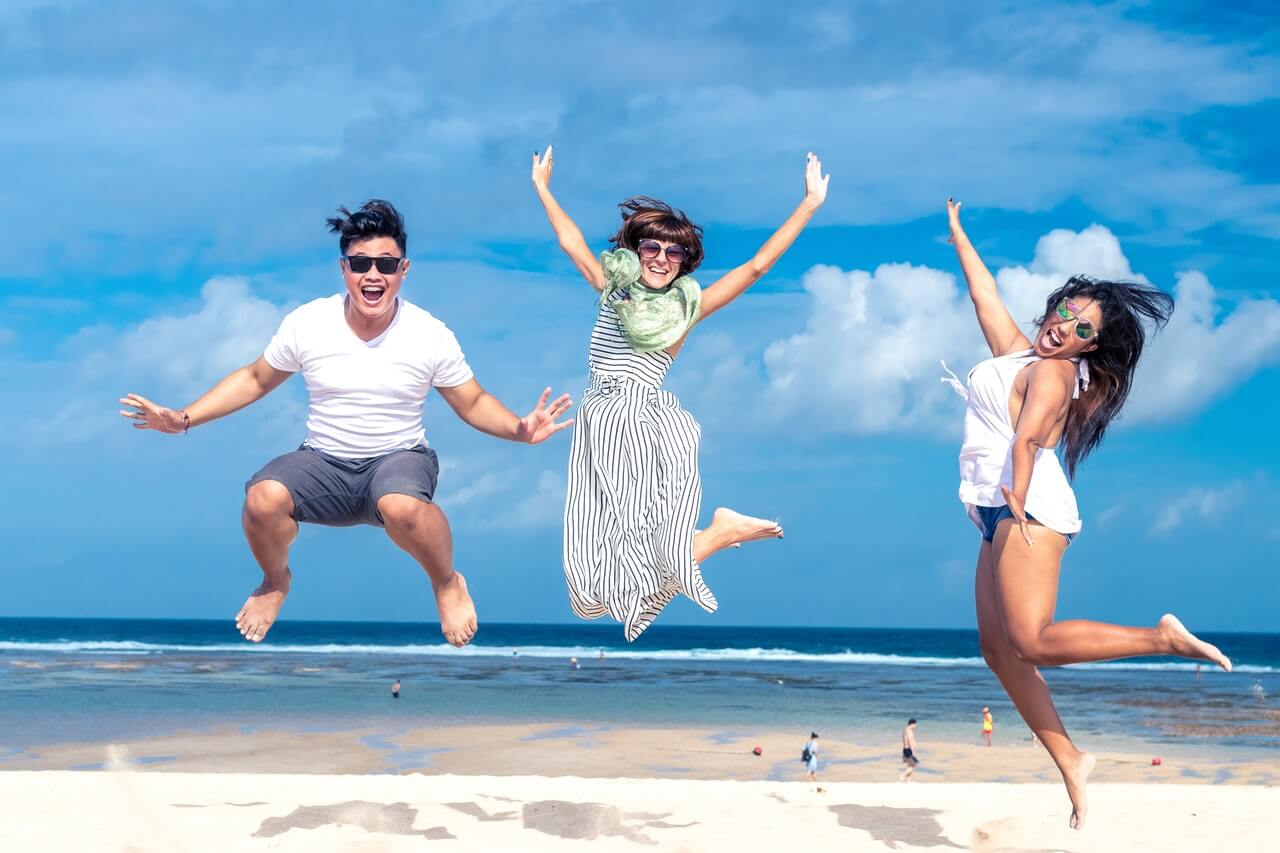 a group of people jumping in the air with their arms out