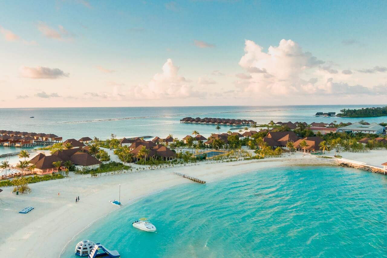 a beach with a body of water and buildings in the background