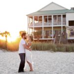 a man and woman kissing in front of a house