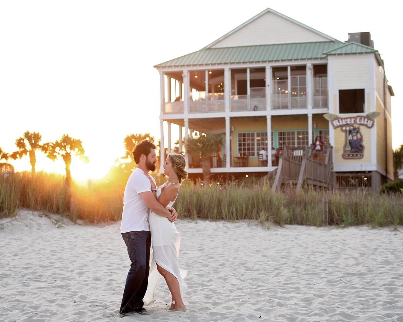 a man and woman kissing in front of a house