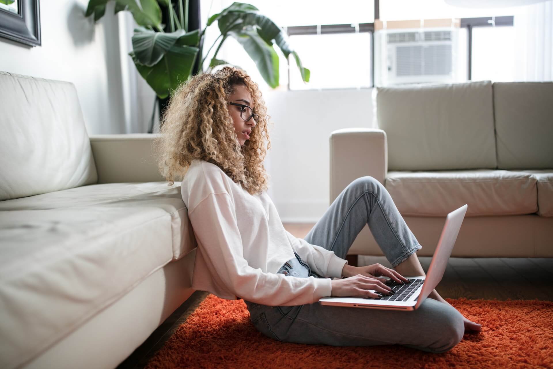 a person sitting on the floor using a laptop